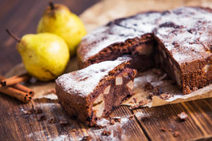 homemade chocolate pie with pears and cinnamon on the wooden rustic table